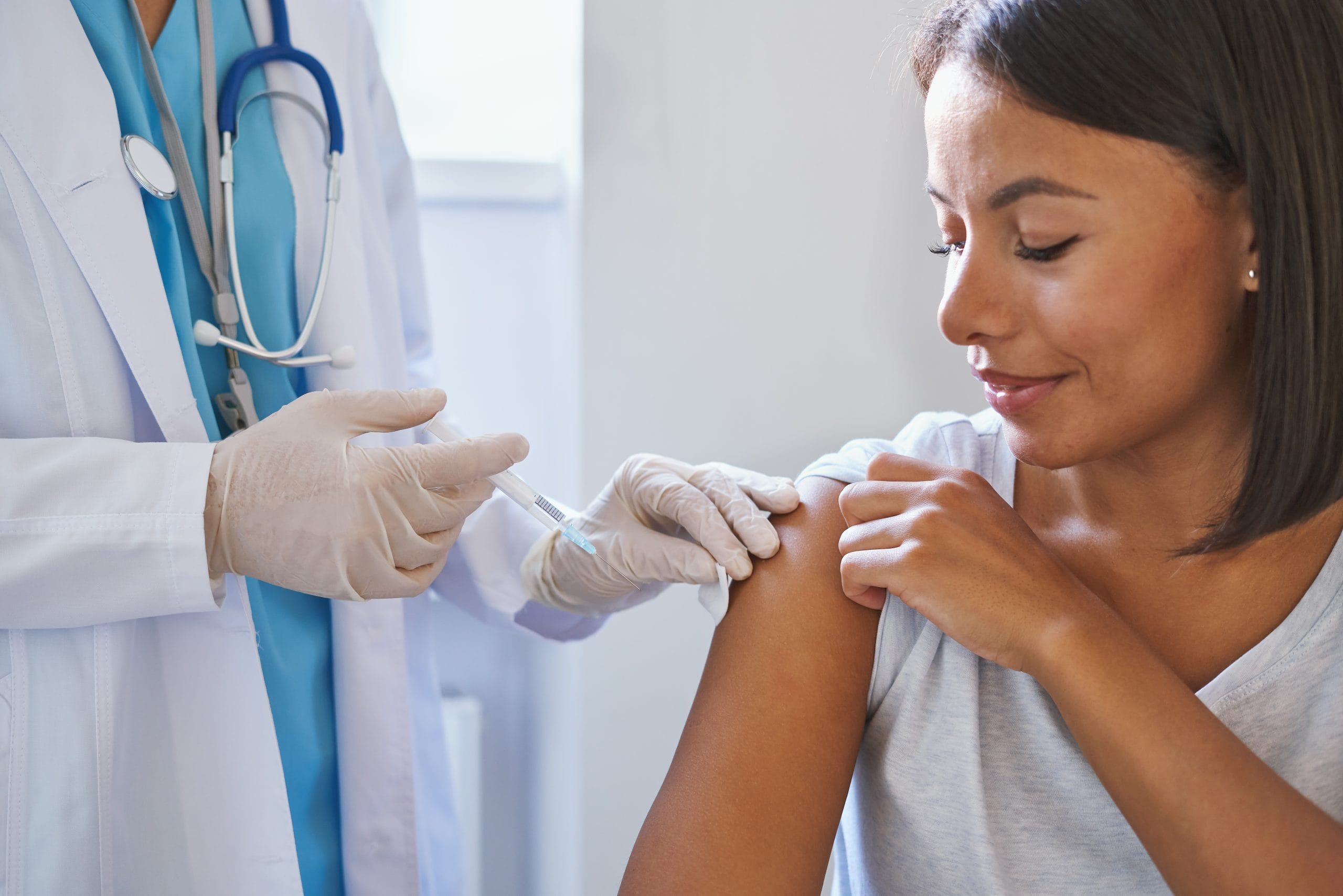 a nurse injecting a woman's arm 