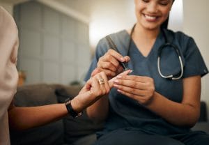 nurse pricking the finger to take a sample from the patient 